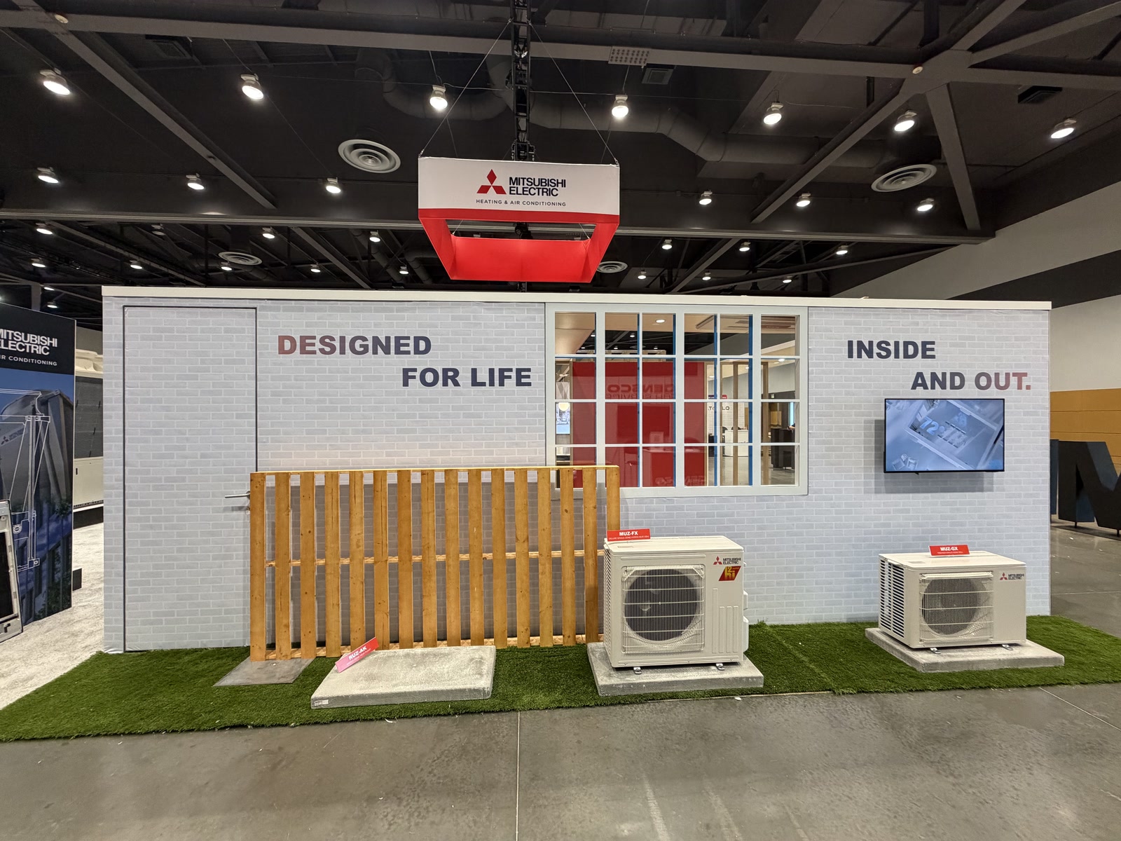 Mitsubishi Electric exterior HVAC vignette with outdoor units, fence, window, and Designed for Life messaging.